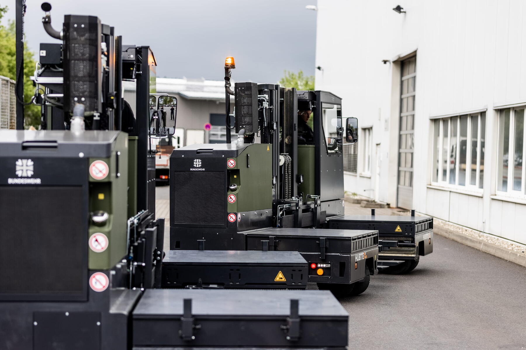 HUBTEX militair transportvoertuig met modulaire laadplatforms naast magazijn
