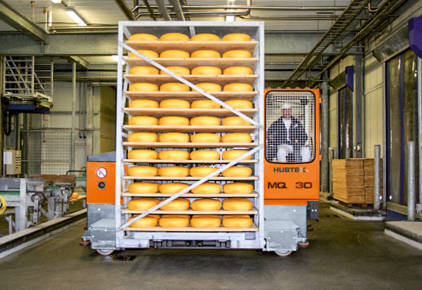 HUBTEX meerwegestapler transporteert rek met kazen in voedselproductieomgeving