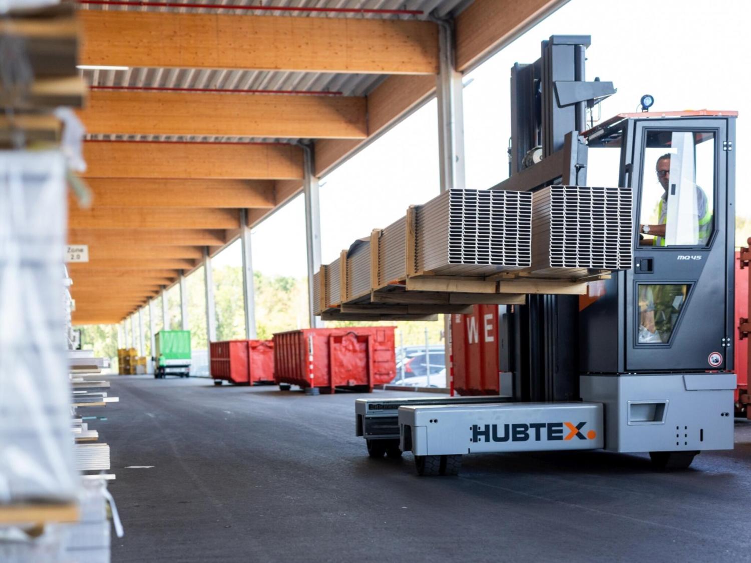 HUBTEX PHOENIX MQ45 meerwegheftruck transporteert lange aluminium profielen in magazijn
