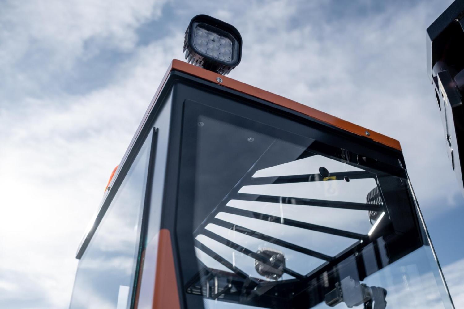 LED werklamp en cabine van HUBTEX MAXX meerwegheftruck tegen blauwe lucht