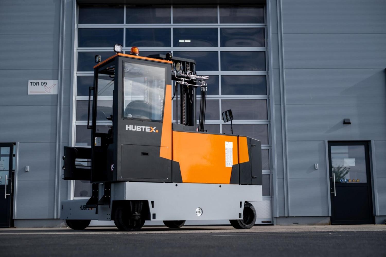 HUBTEX MAXX meerwegheftruck voor industriële bedrijfshal met glazen magazijndeur