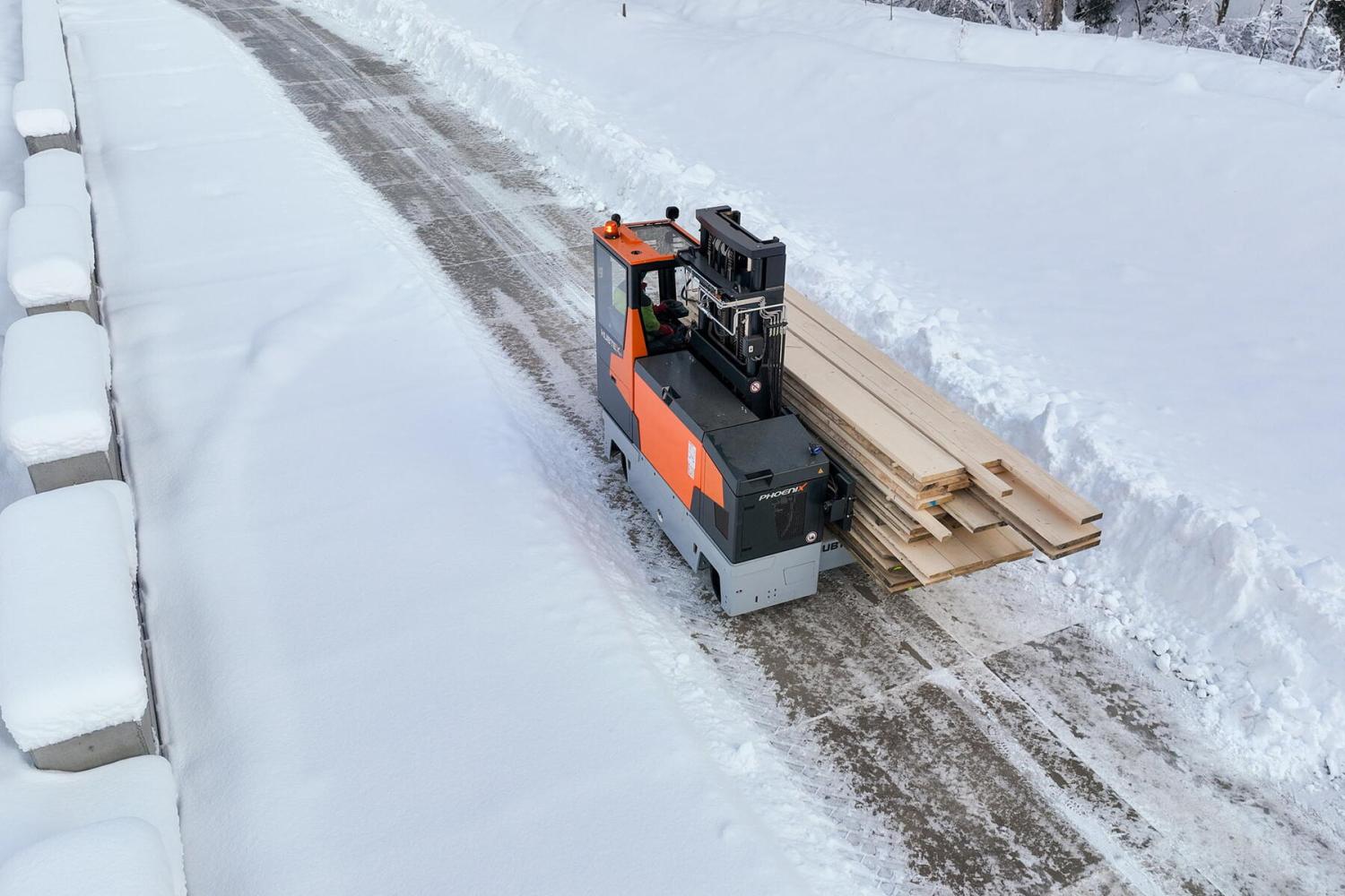 HUBTEX PHOENIX meerwegheftruck vervoert houten planken in winterse omstandigheden