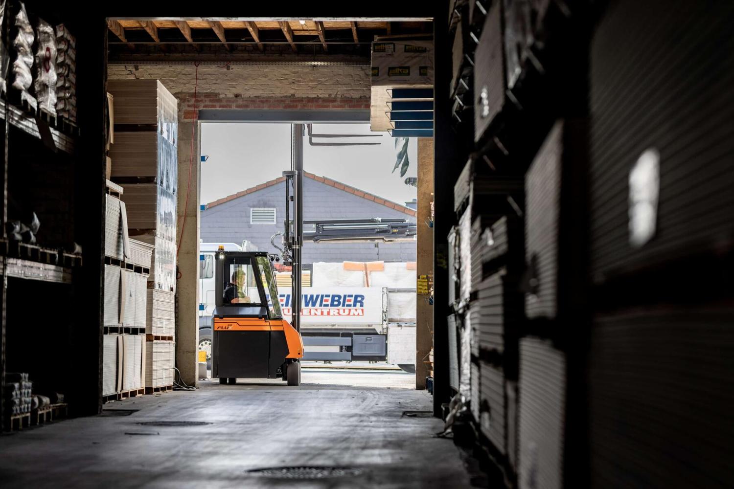 HUBTEX FLUX 30 meerwegheftruck rijdt vanuit magazijn naar buitenterrein met lange materialen