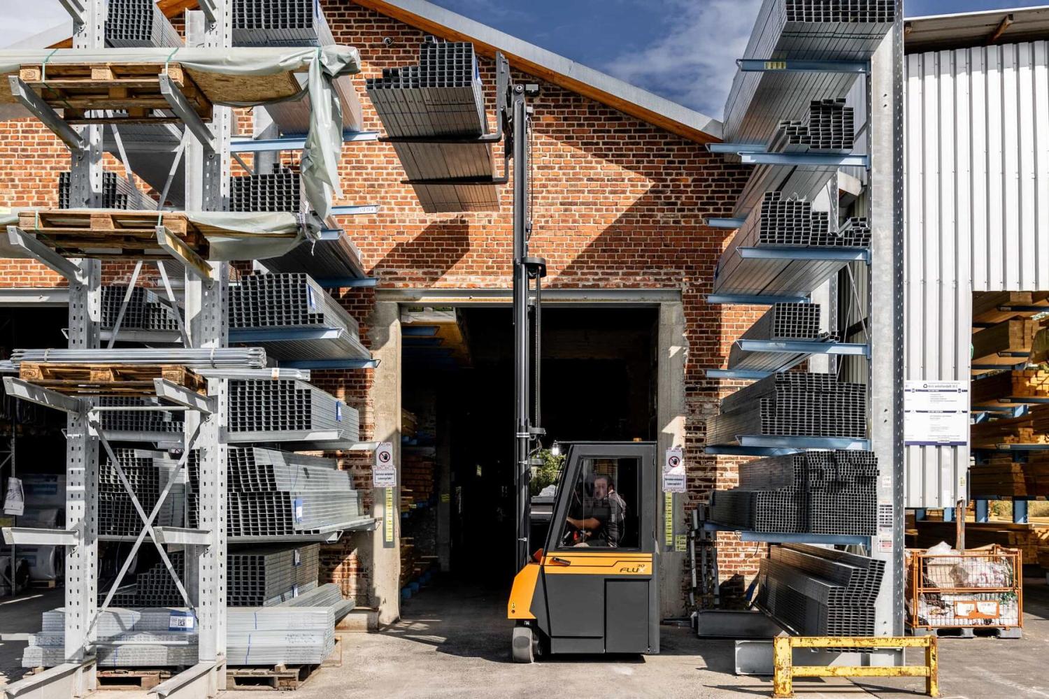 HUBTEX FLUX 30 meerwegheftruck in stellinggang tussen opslagrekken voor lange materialen