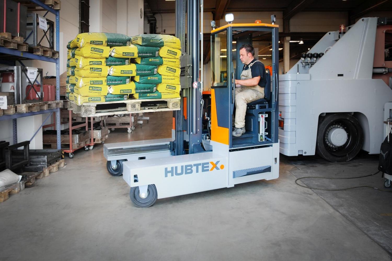 HUBTEX DQ30 compacte meerwegheftruck transporteert pallet met zakgoed in bouwmarkt