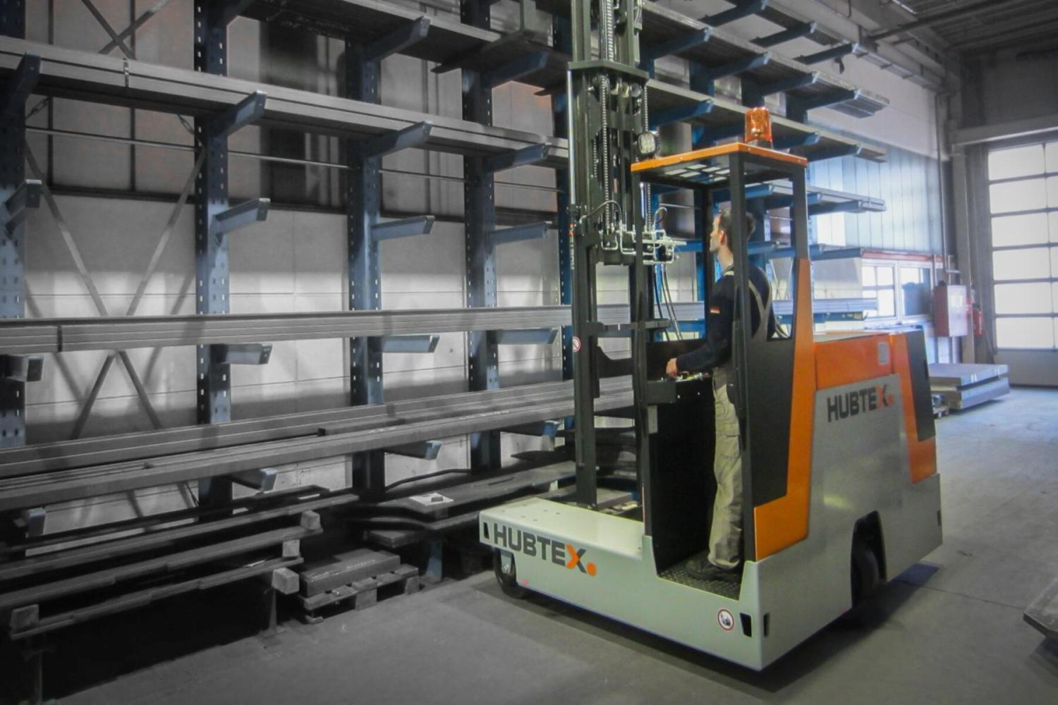 HUBTEX DS27 compacte meerwegheftruck transporteert lange metalen profielen in magazijn