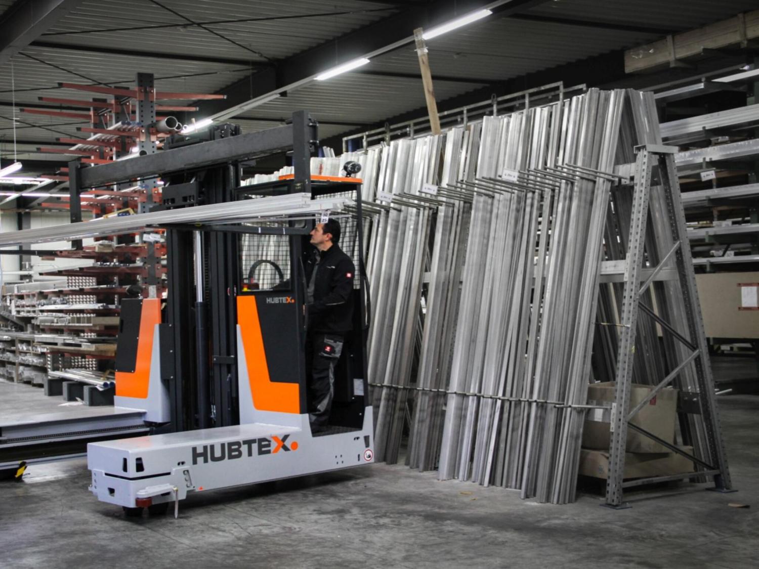 HUBTEX DS27 meerwegheftruck vervoert lange metalen profielen in industriële hal