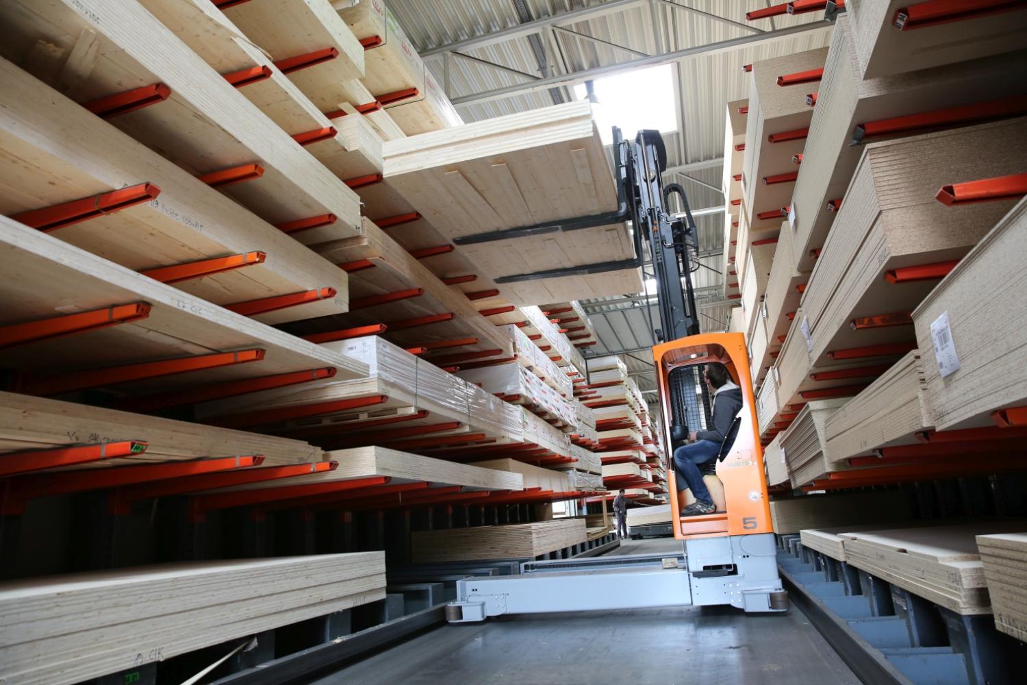 Elektrische HUBTEX zijlader verwerkt lange houten platen in stelling