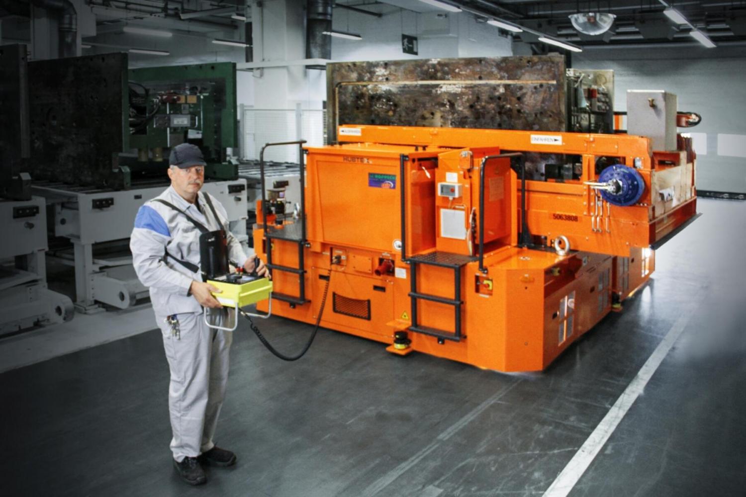 Bediener bestuurt HUBTEX platformwagen met kabelafstandsbediening in fabriek