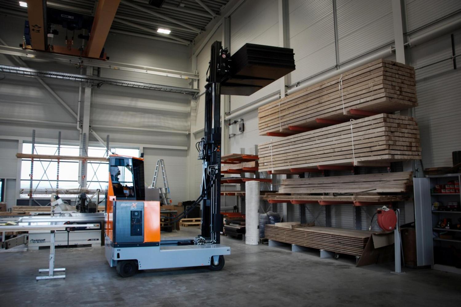HUBTEX MAXX 30 meerwegheftruck transporteert houten platen bij houtopslag in werkplaats