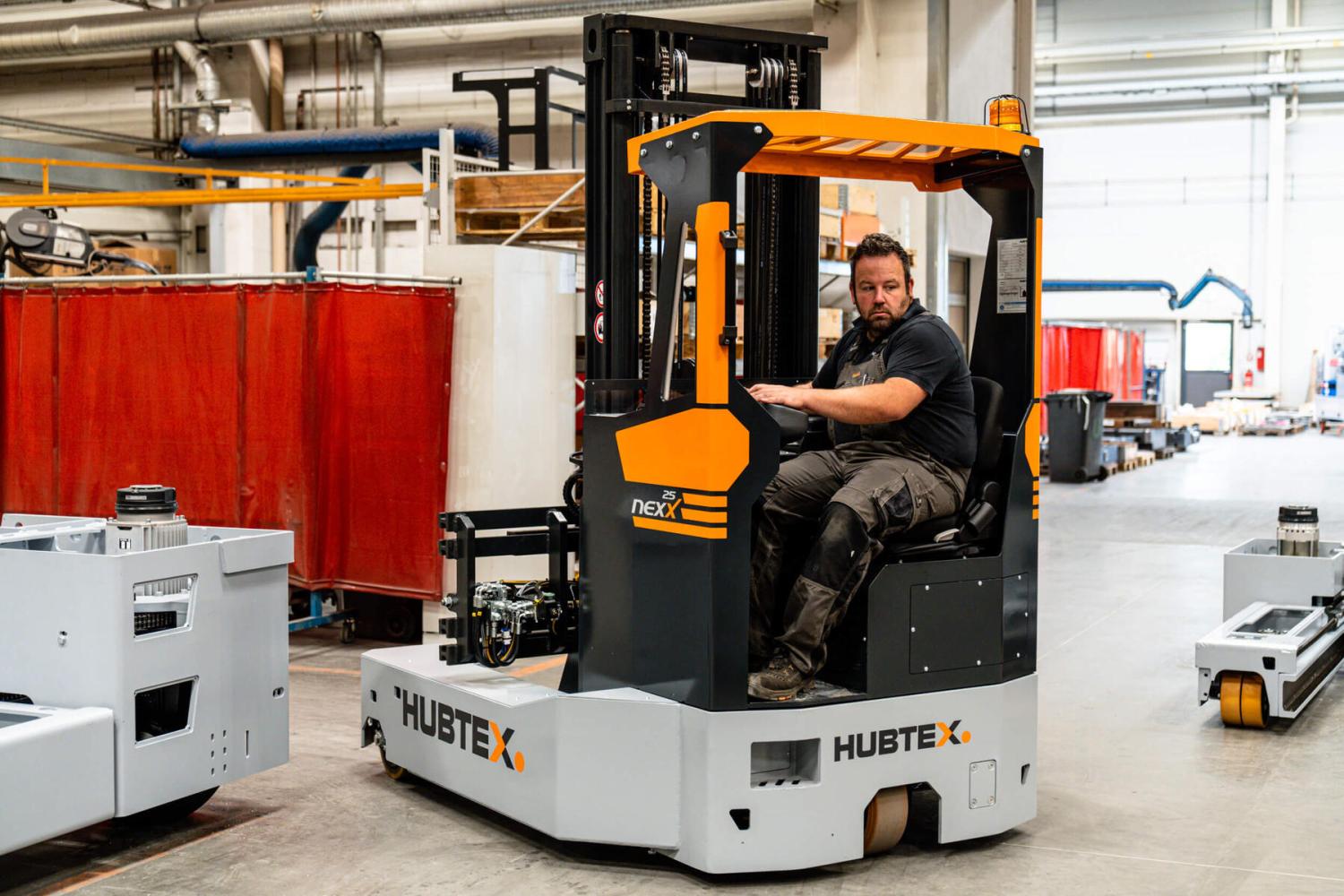 Operator bestuurt HUBTEX NexX 25 meerwegheftruck in industriële productiehal