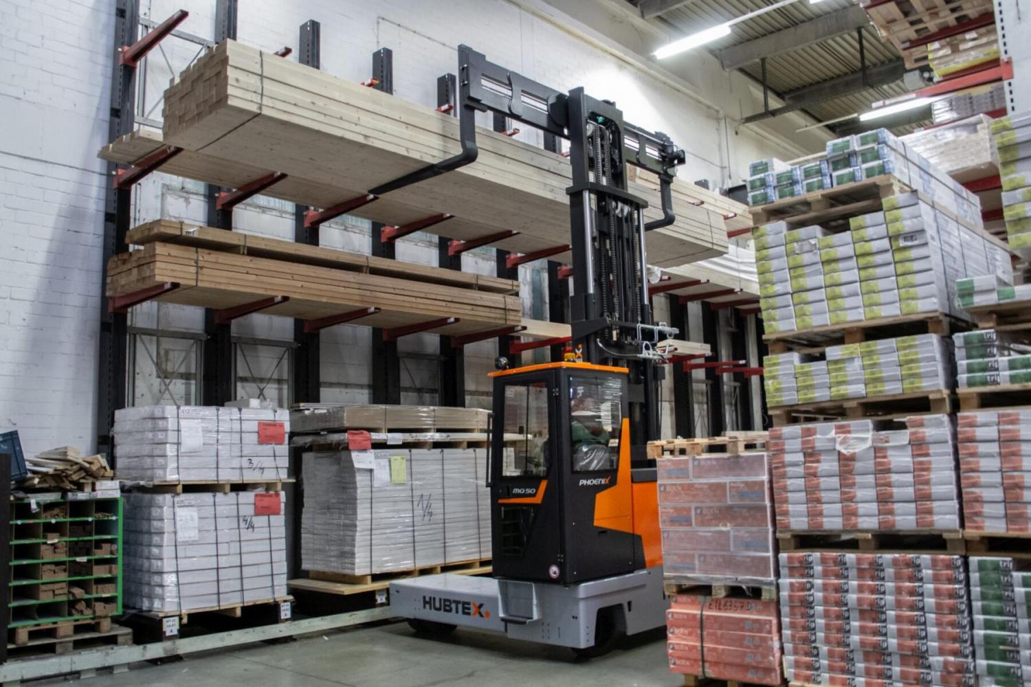 HUBTEX PHOENIX meerwegheftruck stapelt lange bouwmaterialen in magazijn