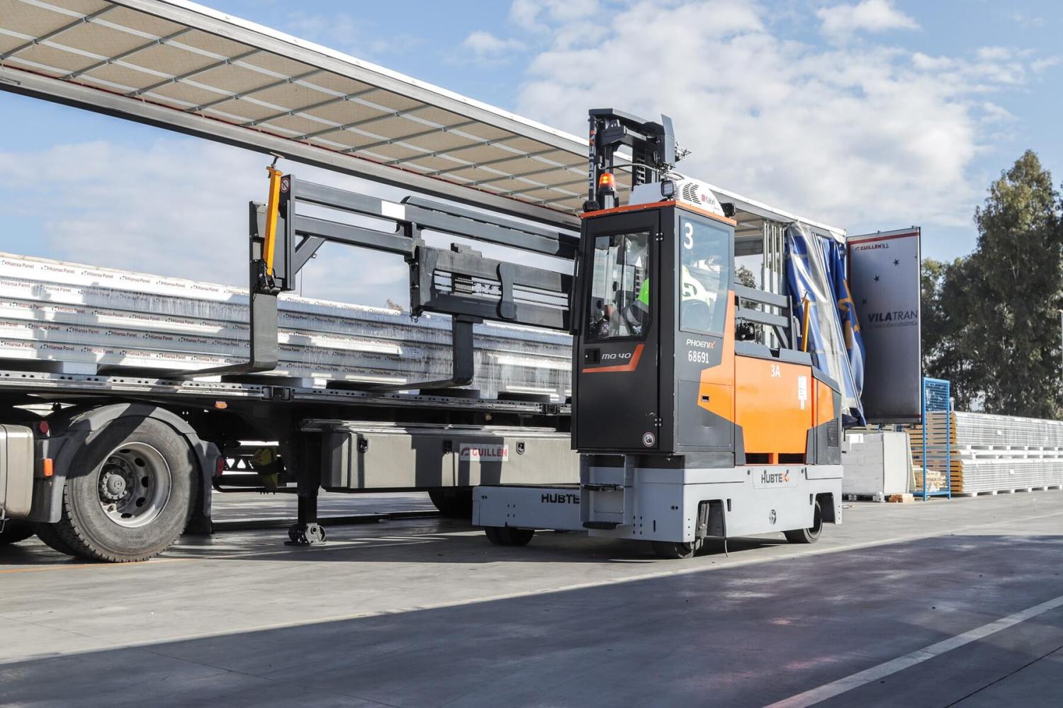HUBTEX PHOENIX MQ40 meerwegheftruck laadt lange metalen profielen op vrachtwagen